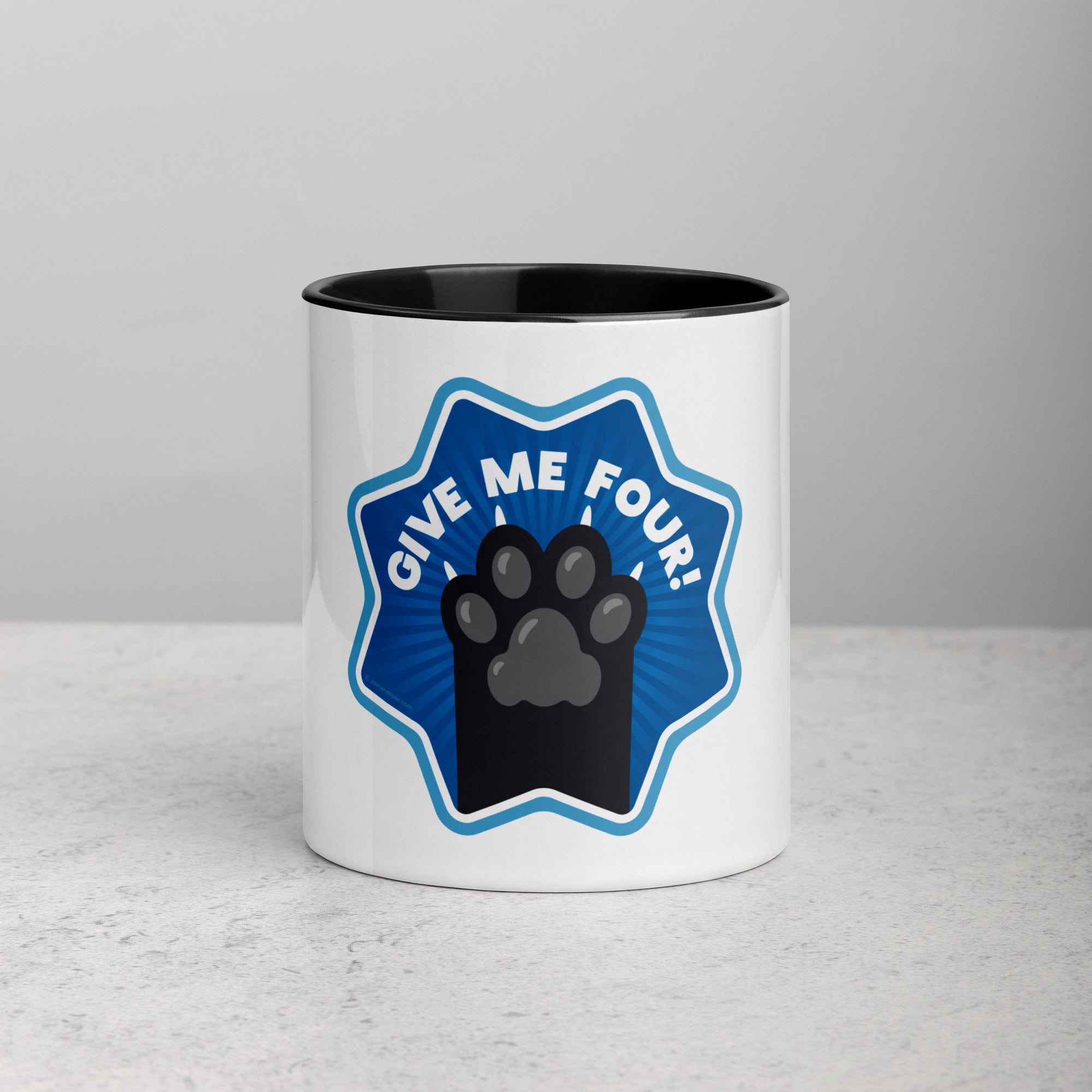 front facing image of a white mug with black interior and handle. Mug has image of black cats paw on a blue 8 sided star with the text 'give me four' 
